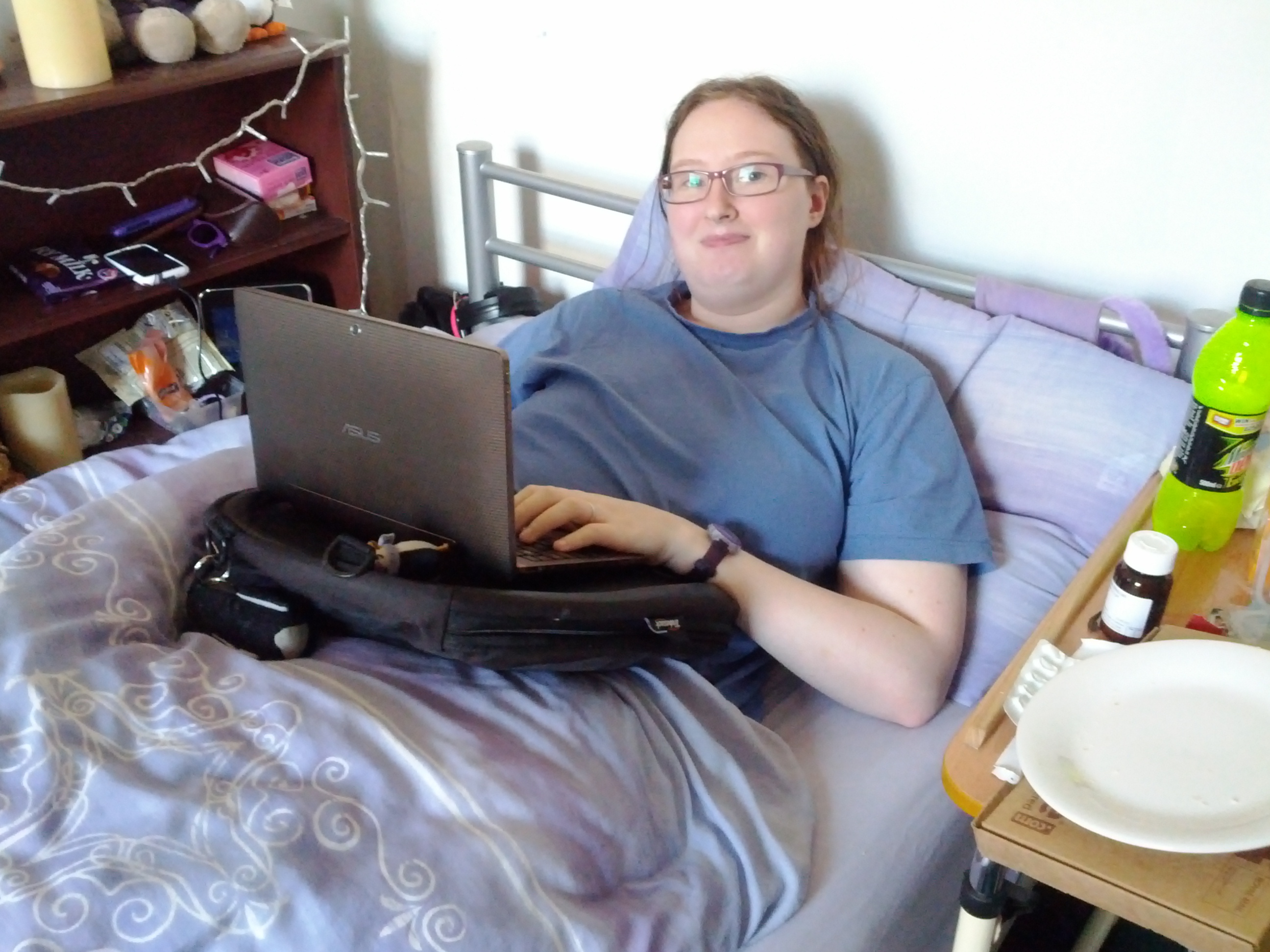 Danni in bed using a laptop on her trabasack