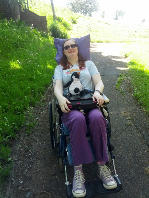 Danni outside in their wheelchair